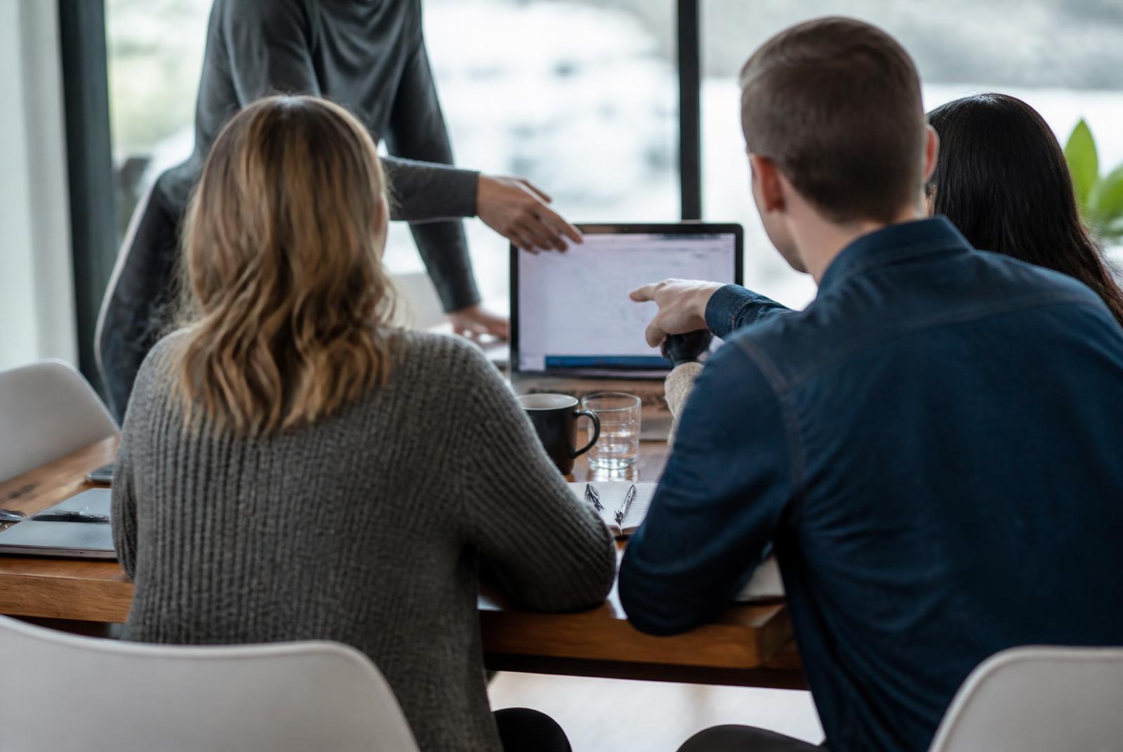 Team in conversation around a table at the Avensus office